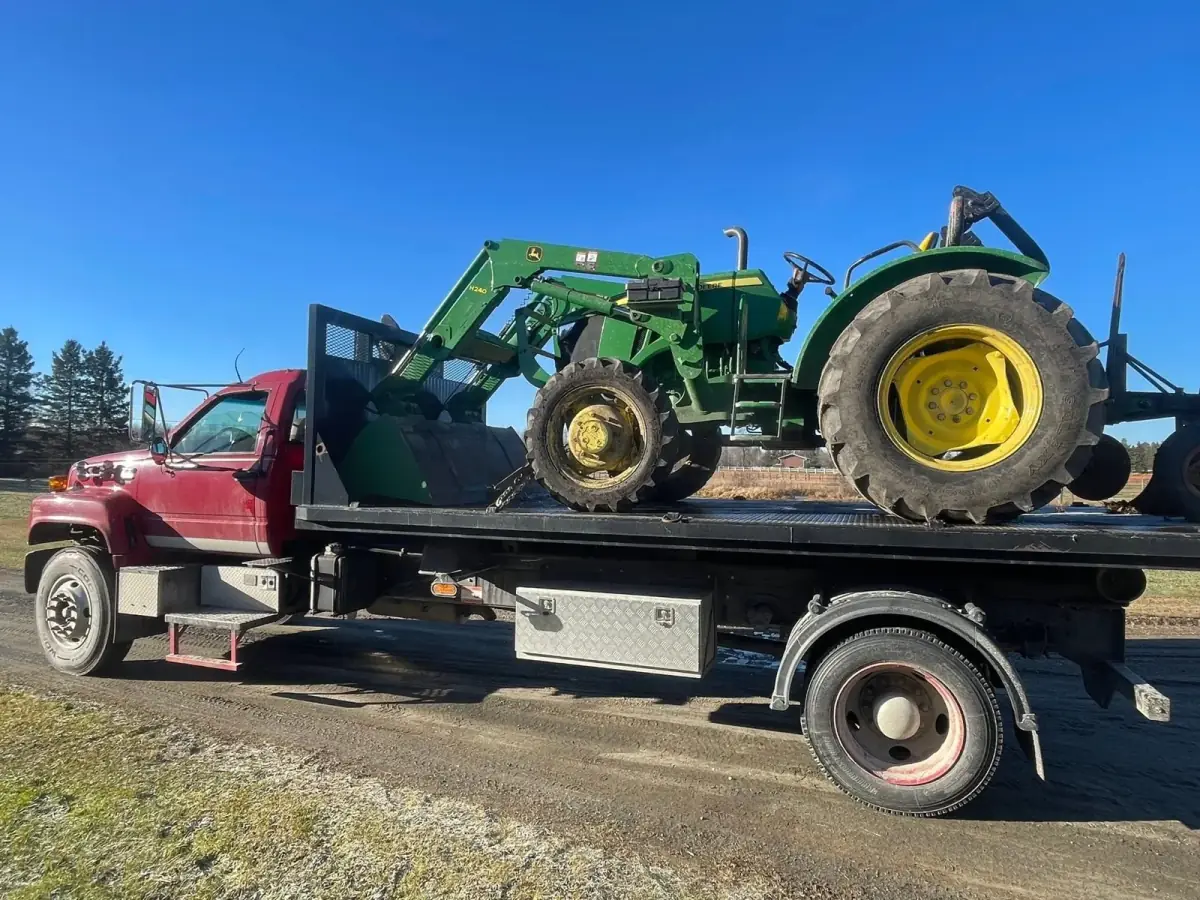 Flatbed float hauling a tractor