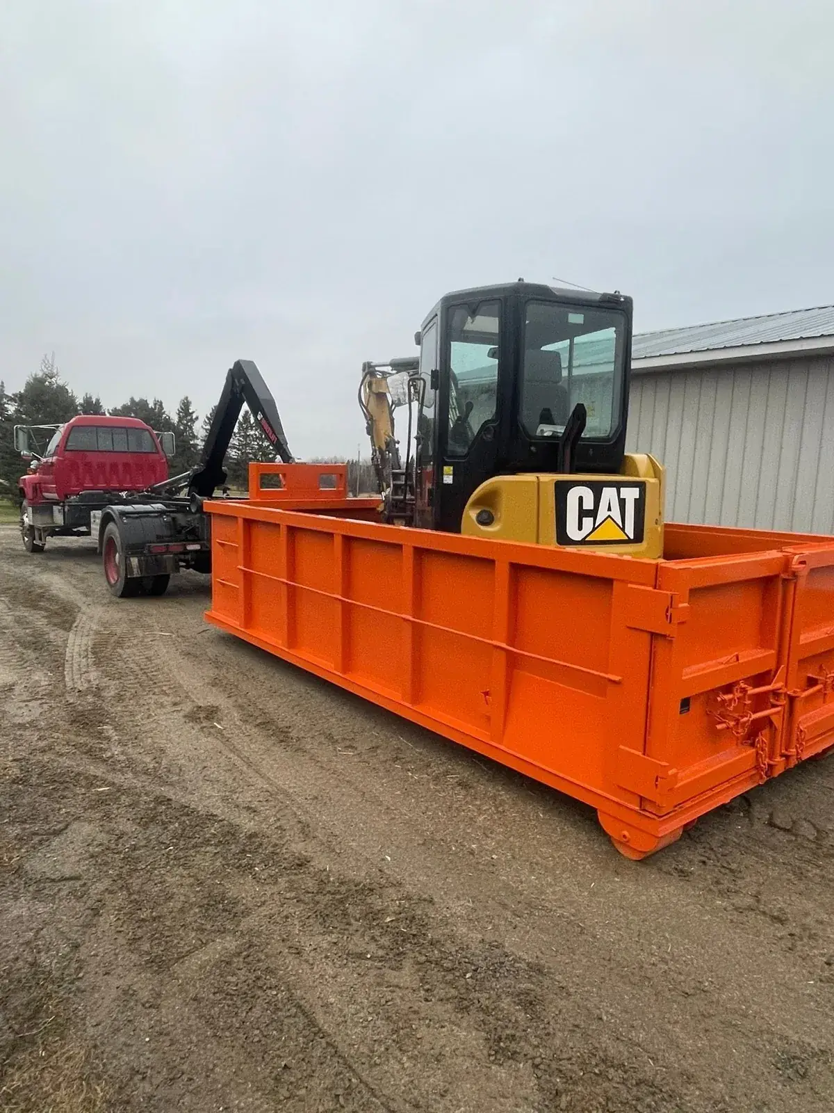 Mini excavator beside a bin